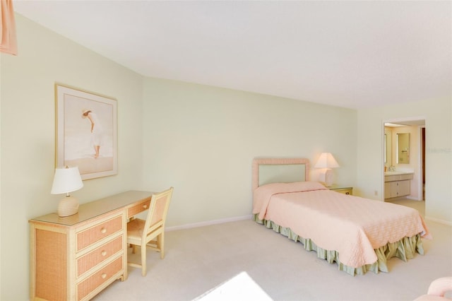 bedroom featuring light carpet and connected bathroom