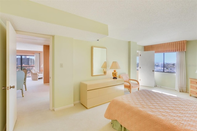 bedroom with a textured ceiling, light colored carpet, and multiple windows