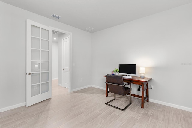 office with french doors and light hardwood / wood-style floors