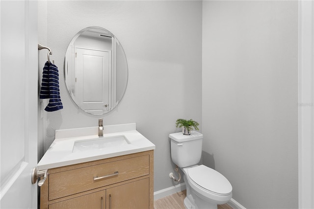 bathroom with vanity, toilet, and wood-type flooring