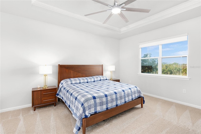 bedroom featuring light colored carpet, a raised ceiling, ceiling fan, and ornamental molding