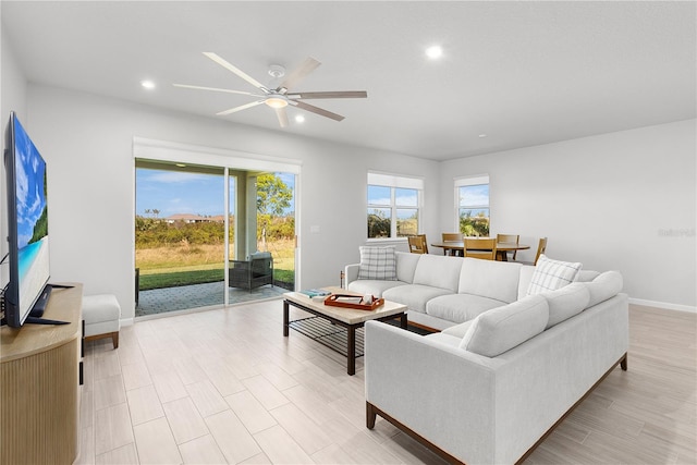 living room with ceiling fan and light wood-type flooring