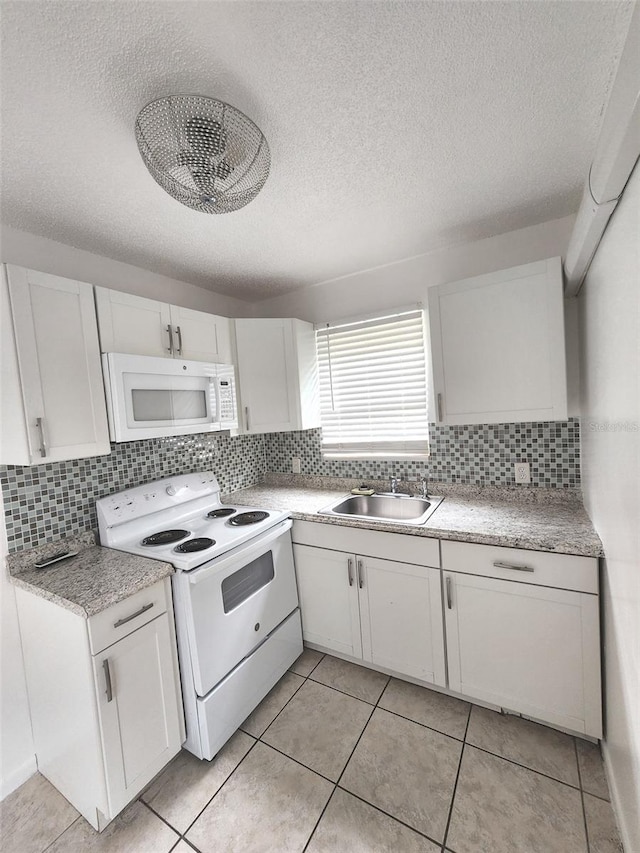 kitchen with white cabinets, backsplash, white appliances, and sink