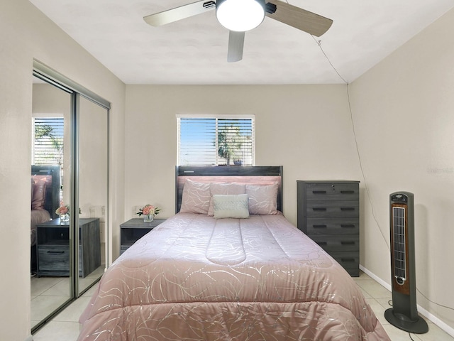 tiled bedroom with multiple windows, ceiling fan, and a closet