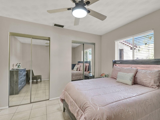 3869 S Lake Dr Unit 146, Tampa, FL 33614 - bedroom featuring multiple closets, light tile patterned flooring, baseboards, and ceiling fan