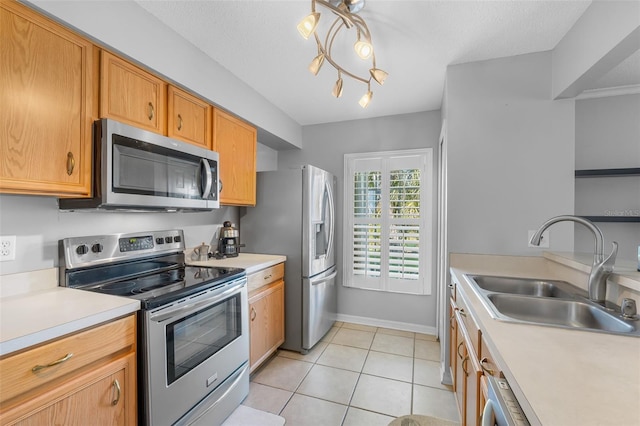 kitchen featuring sink, an inviting chandelier, a textured ceiling, light tile patterned floors, and appliances with stainless steel finishes