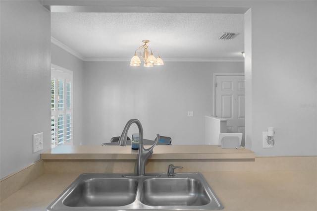 kitchen featuring sink, a notable chandelier, crown molding, a textured ceiling, and decorative light fixtures