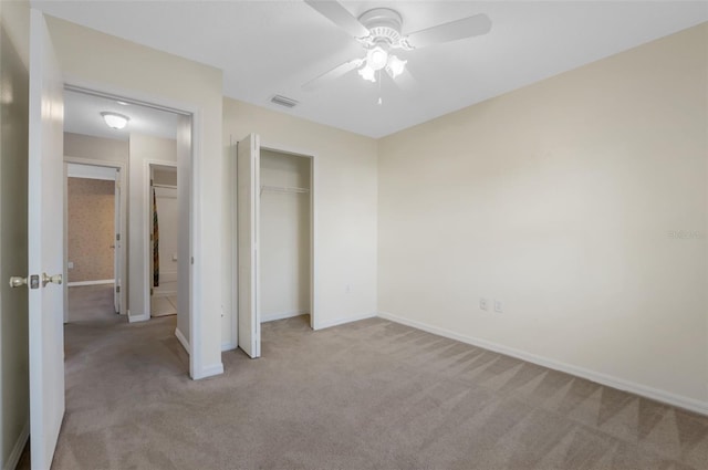 unfurnished bedroom with ceiling fan, light carpet, and a closet