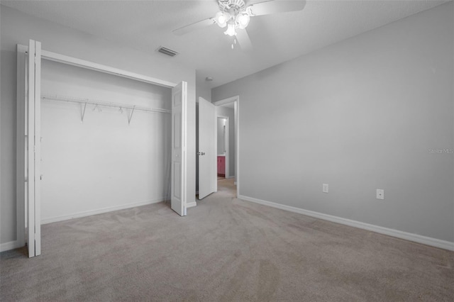 unfurnished bedroom with ceiling fan, a closet, and light colored carpet