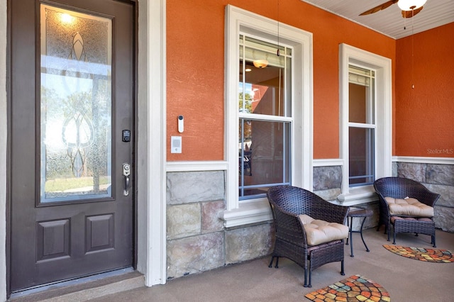 entrance to property with a porch, elevator, and ceiling fan