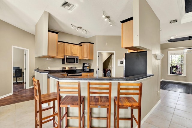 kitchen with a kitchen breakfast bar, kitchen peninsula, stainless steel appliances, and light hardwood / wood-style floors