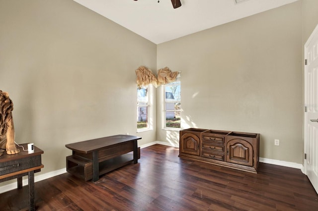 living area with ceiling fan, dark hardwood / wood-style flooring, and vaulted ceiling