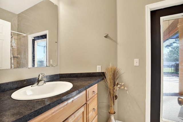 bathroom featuring vanity and tiled shower