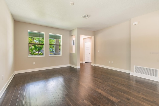 empty room featuring dark hardwood / wood-style flooring and a textured ceiling