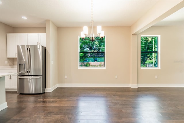 kitchen featuring pendant lighting, stainless steel fridge, white cabinetry, and dark wood-type flooring