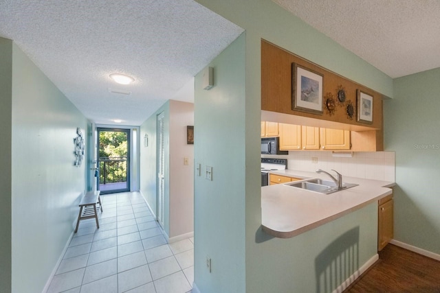 kitchen featuring light tile patterned flooring, a textured ceiling, electric range, and sink