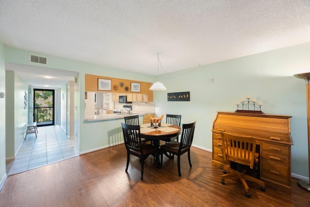 dining room featuring hardwood / wood-style floors, a textured ceiling, and sink