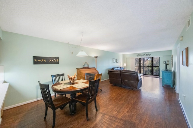 dining room featuring dark hardwood / wood-style flooring and a textured ceiling