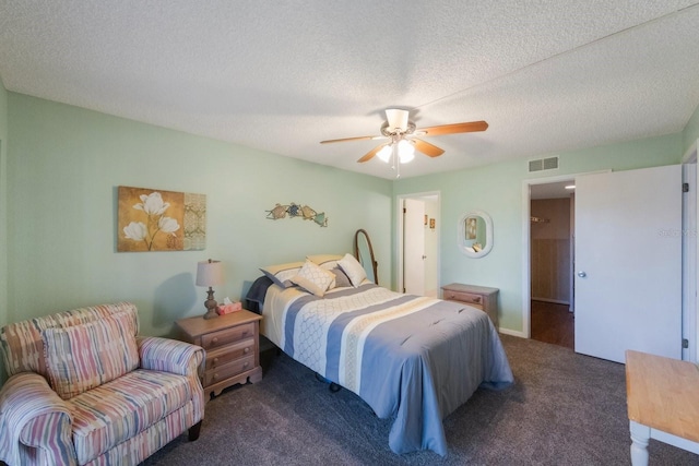 bedroom with ceiling fan, dark carpet, and a textured ceiling