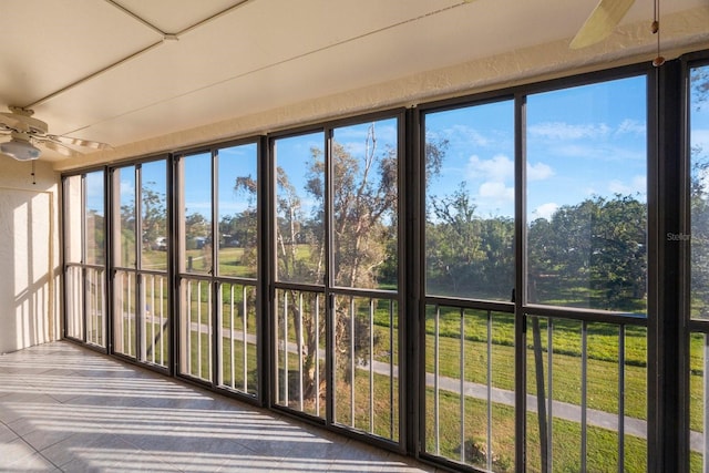 unfurnished sunroom featuring ceiling fan