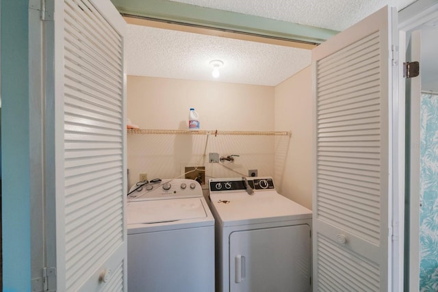 clothes washing area with a textured ceiling and washing machine and dryer