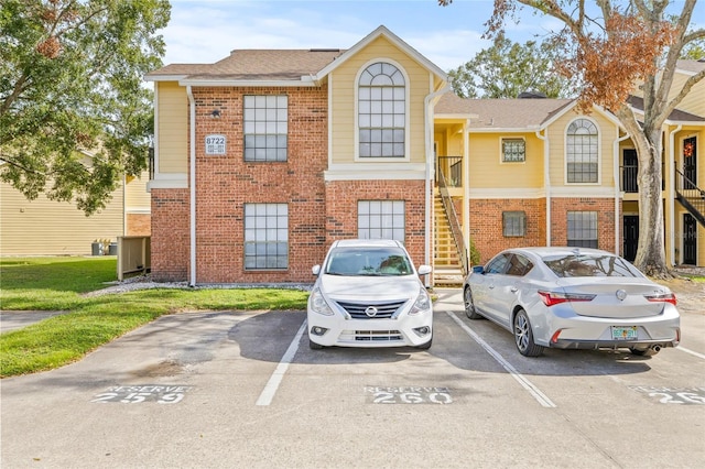 8722 Mallard Reserve Dr Unit 204, Tampa, FL 33614 - view of property with brick siding, uncovered parking, and stairs