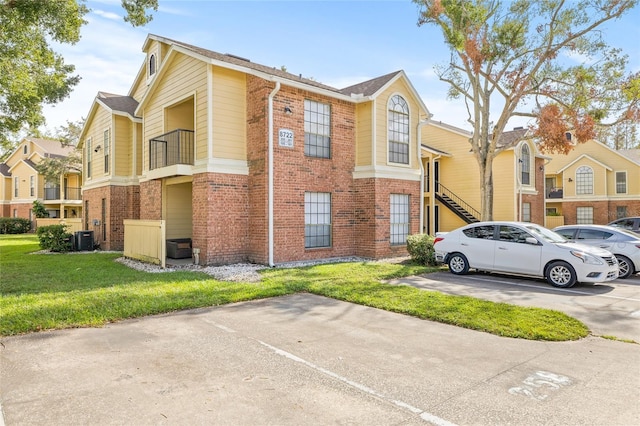8722 Mallard Reserve Dr Unit 204, Tampa, FL 33614 - view of building exterior with uncovered parking, central AC unit, and a residential view