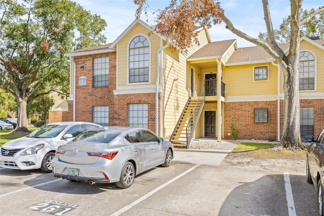 8722 Mallard Reserve Dr Unit 204, Tampa, FL 33614 - view of front facade with brick siding, uncovered parking, and a shingled roof