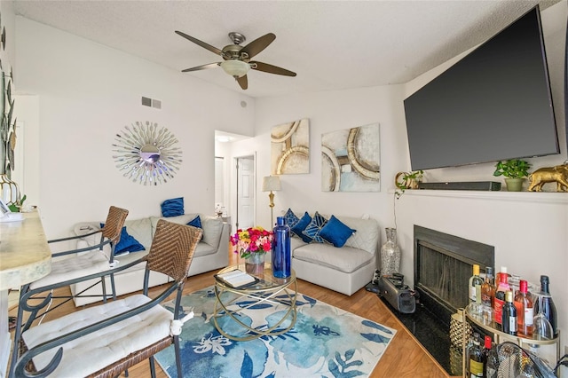 living room featuring lofted ceiling, ceiling fan, and wood-type flooring