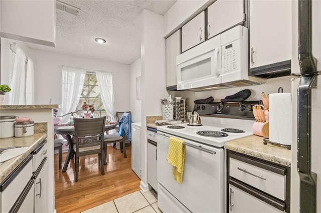 kitchen featuring white cabinetry, white appliances, and a textured ceiling