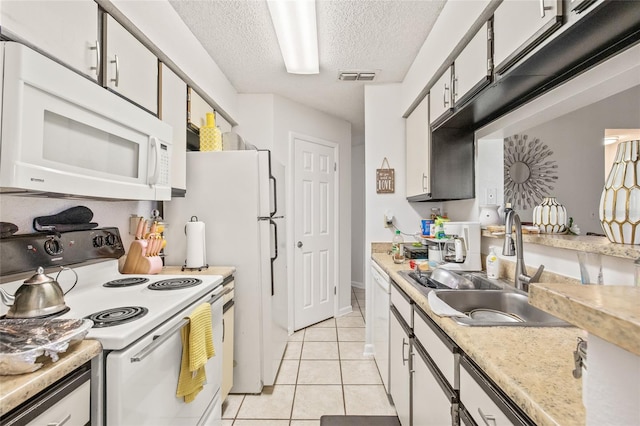 kitchen with white cabinets, a textured ceiling, and white appliances