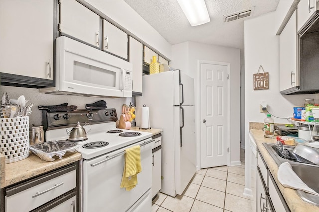 8722 Mallard Reserve Dr Unit 204, Tampa, FL 33614 - kitchen featuring white appliances, light countertops, light tile patterned floors, a textured ceiling, and a sink