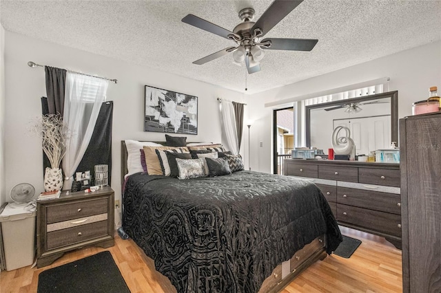 bedroom with ceiling fan, light hardwood / wood-style floors, and a textured ceiling