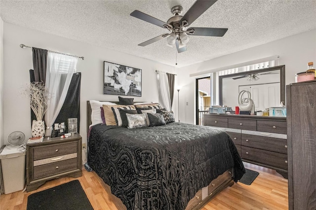 8722 Mallard Reserve Dr Unit 204, Tampa, FL 33614 - bedroom featuring light wood finished floors, a textured ceiling, and a ceiling fan