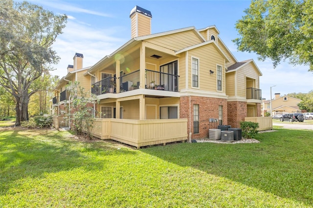 rear view of property with a lawn and a balcony