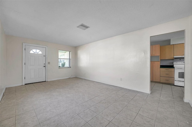 tiled foyer with a textured ceiling