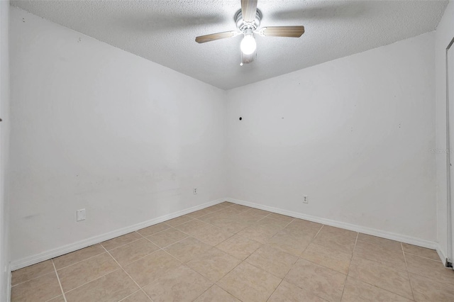 unfurnished room with ceiling fan, light tile patterned floors, and a textured ceiling