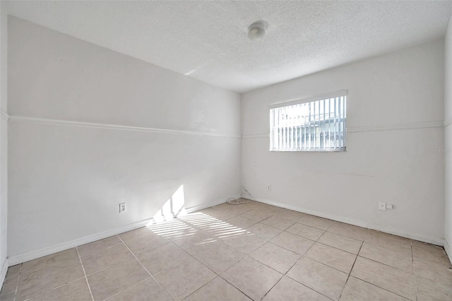 unfurnished room featuring light tile patterned floors and a textured ceiling