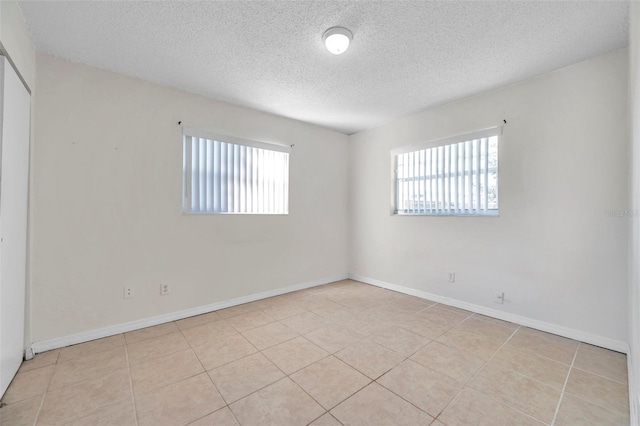 tiled spare room featuring a textured ceiling