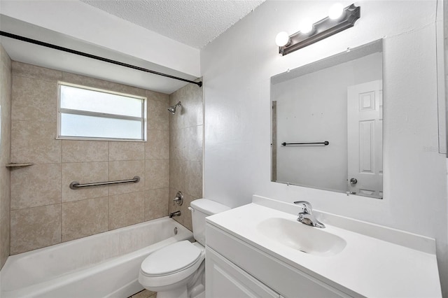 full bathroom with vanity, a textured ceiling, toilet, and tiled shower / bath