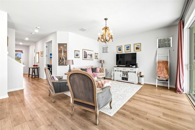 living room featuring light hardwood / wood-style floors and a chandelier