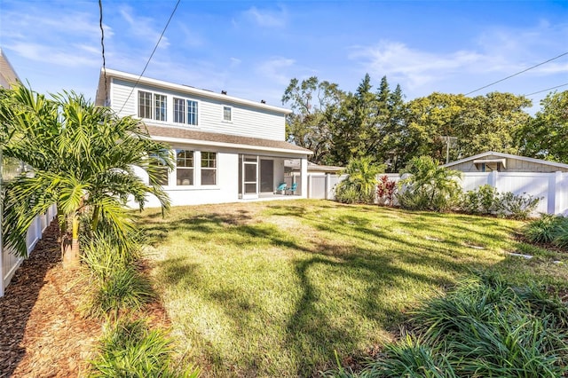 rear view of house featuring a lawn