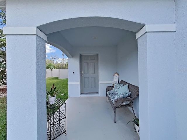 entrance to property with a lawn and a patio