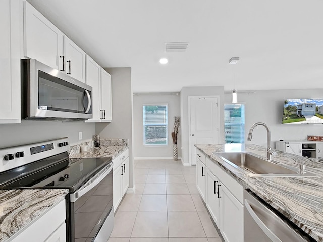 kitchen featuring white cabinets, light tile patterned floors, stainless steel appliances, and sink