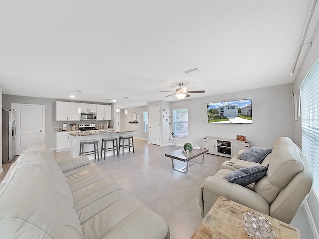 living room with ceiling fan and sink