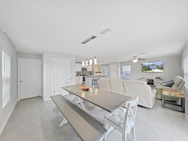 dining space with light tile patterned floors and ceiling fan