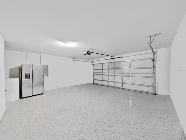 garage featuring electric panel, stainless steel refrigerator with ice dispenser, and a garage door opener