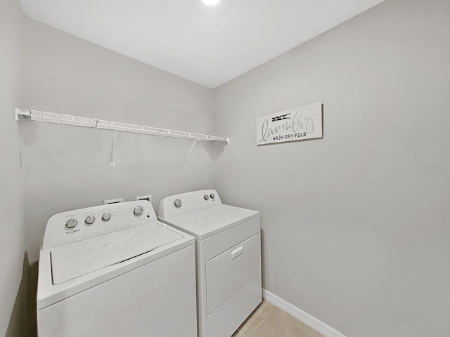 laundry room featuring washing machine and dryer and light tile patterned floors