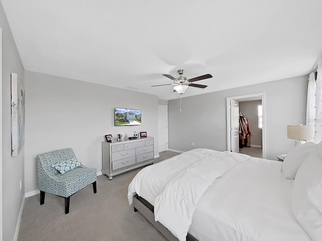 carpeted bedroom featuring a closet, a spacious closet, and ceiling fan