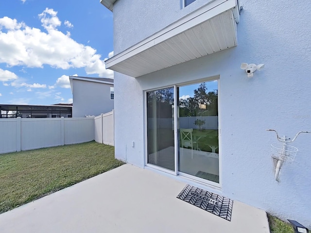 entrance to property with a patio area and a yard